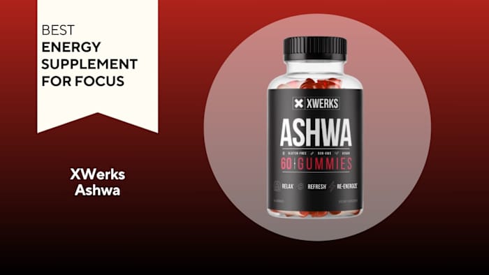 Clear pill bottle filled with red pills against a red background